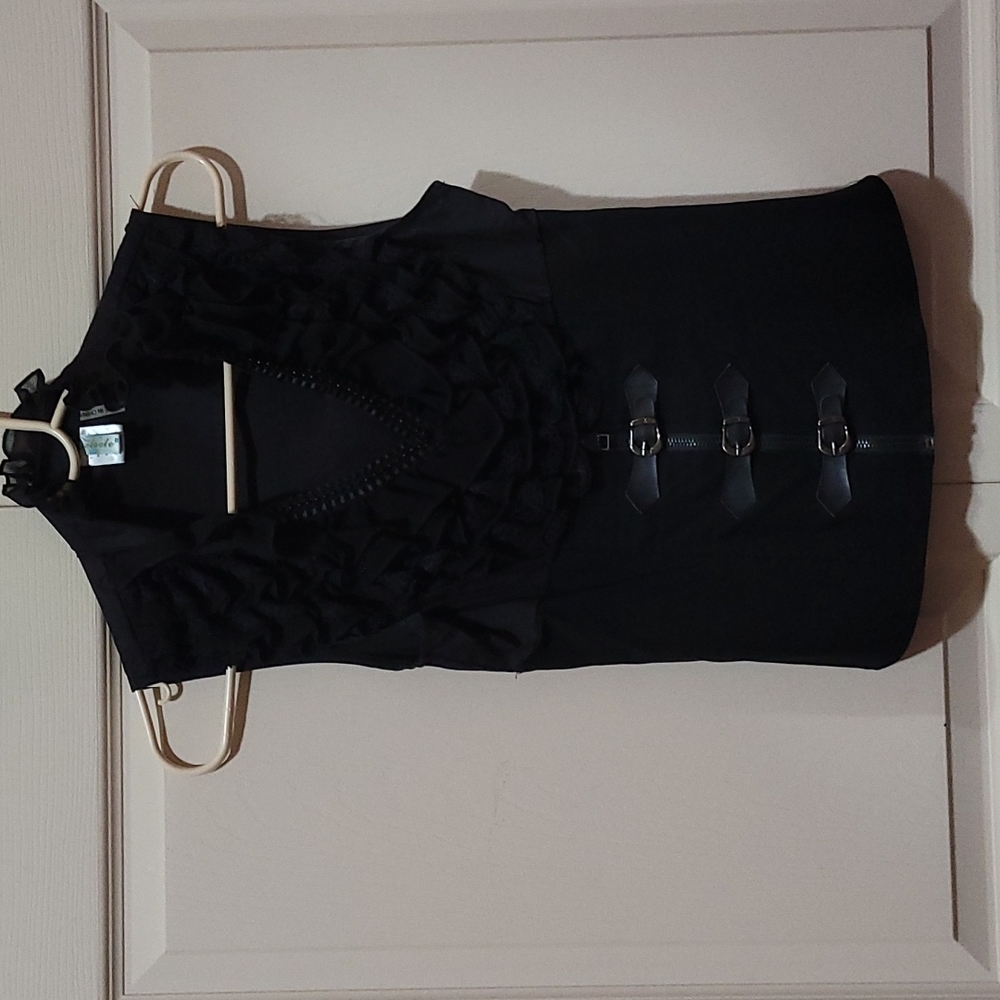 Sleeveless top with ruffles and buckles in the front.